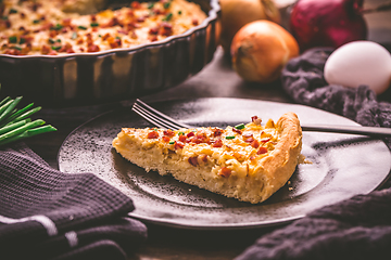 Image showing Piece of homemade onion tart or pie with bacon and chives