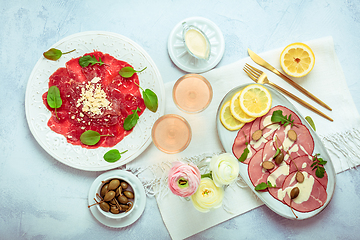 Image showing Appetizers - Vitello tonnato and beef Carpaccio with two glasses of rose wine