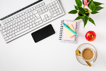 Image showing Workplace and office desk with coffee, apple, laptop, headset and smarthpone