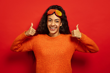 Image showing African-american young woman\'s portrait in ski mask on red background