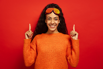 Image showing African-american young woman\'s portrait in ski mask on red background