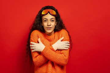 Image showing African-american young woman\'s portrait in ski mask on red background