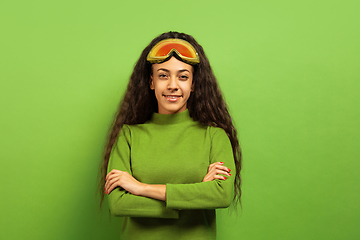 Image showing African-american young woman\'s portrait in ski mask on green background