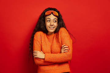 Image showing African-american young woman\'s portrait in ski mask on red background