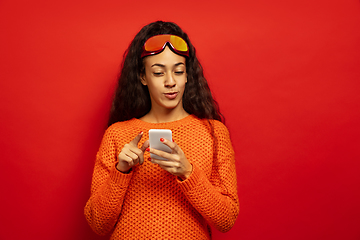 Image showing African-american young woman\'s portrait in ski mask on red background