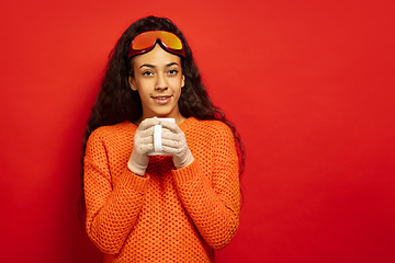 Image showing African-american young woman\'s portrait in ski mask on red background