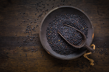 Image showing Beluga lentils in bowl on dark wooden background