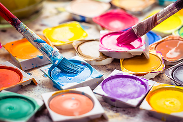 Image showing Set of watercolor paints and paintbrushes for painting closeup. 