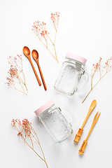 Image showing Empty drinking cups or jars with wooden spoons on white background