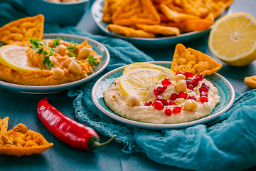 Image showing Homemade spicy humus with pomegranate seeds, chilli and chickpeas tortilla chips