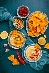 Image showing Homemade spicy humus with pomegranate seeds, chilli and chickpeas tortilla chips