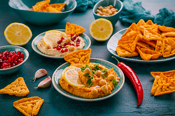 Image showing Homemade spicy humus with pomegranate seeds, chilli and chickpeas tortilla chips