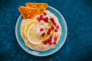 Image showing Homemade spicy humus with pomegranate seeds and chickpeas tortilla chips