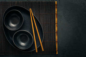 Image showing Pottery bowls or ceramics in blacke tone with chopsticks