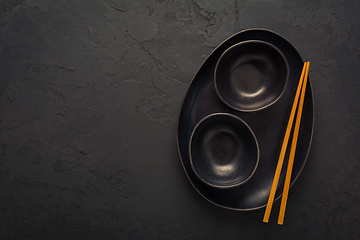 Image showing Pottery bowls or ceramics in blacke tone with chopsticks