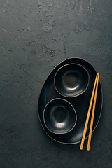 Image showing Pottery bowls or ceramics in blacke tone with chopsticks