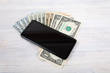 Image showing cellular phone and American dollar money on white