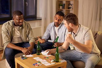 Image showing smiling male friends playing cards at home