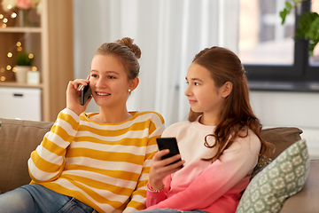 Image showing happy teenage girls with smartphones at home