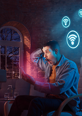 Image showing Man using gadget and receive neon notifications at home at night