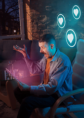 Image showing Man using gadget and receive neon notifications at home at night