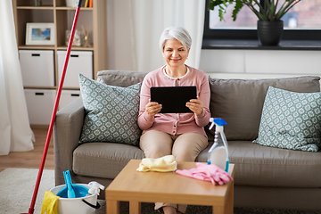 Image showing senior woman using tablet pc after cleaning home