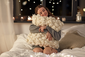 Image showing happy young woman with soft pillow in bed at home