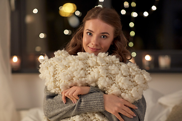 Image showing happy young woman with soft pillow in bed at home