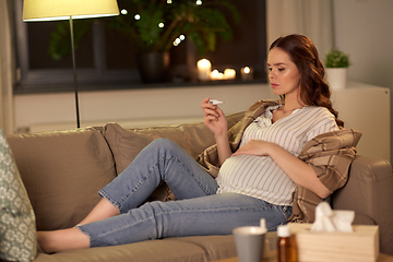 Image showing sick pregnant woman with thermometer at home
