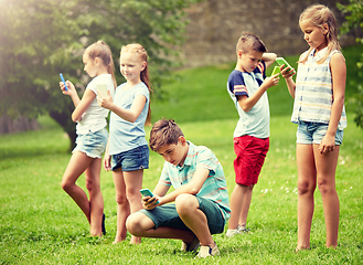 Image showing kids with smartphones playing game in summer park