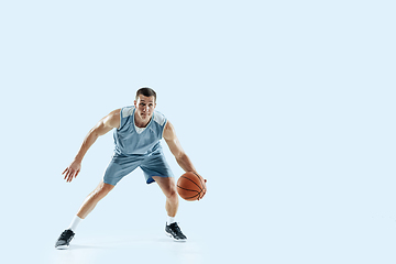 Image showing Young caucasian basketball player against white studio background