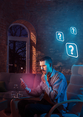 Image showing Man using gadget and receive neon notifications at home at night