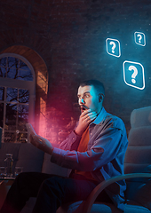 Image showing Man using gadget and receive neon notifications at home at night