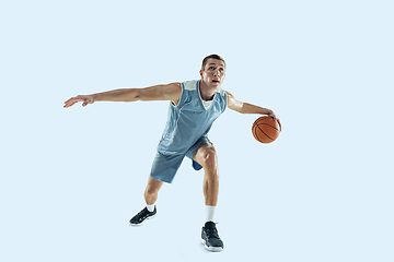 Image showing Young caucasian basketball player against white studio background