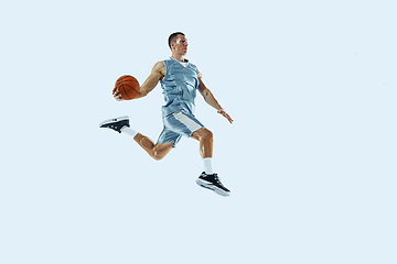 Image showing Young caucasian basketball player against white studio background