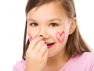 Image showing Little girl is applying lipstick on her nose