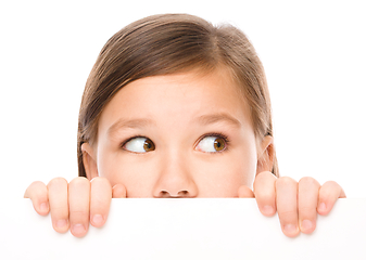 Image showing Little girl is looking from out blank board