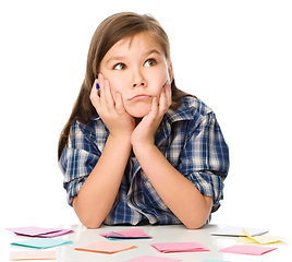 Image showing Girl is writing on color stickers using pen