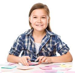 Image showing Girl is writing on color stickers using pen