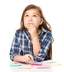 Image showing Girl is writing on color stickers using pen