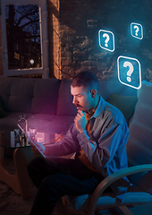 Image showing Man using gadget and receive neon notifications at home at night