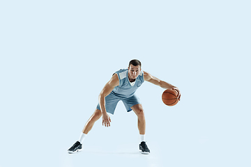 Image showing Young caucasian basketball player against white studio background