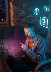 Image showing Man using gadget and receive neon notifications at home at night