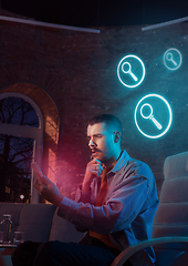 Image showing Man using gadget and receive neon notifications at home at night