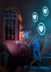 Image showing Man using gadget and receive neon notifications at home at night