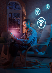 Image showing Man using gadget and receive neon notifications at home at night