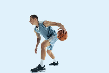 Image showing Young caucasian basketball player against white studio background