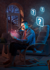 Image showing Man using gadget and receive neon notifications at home at night