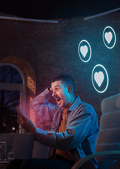 Image showing Man using gadget and receive neon notifications at home at night