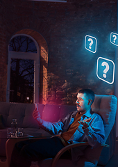 Image showing Man using gadget and receive neon notifications at home at night